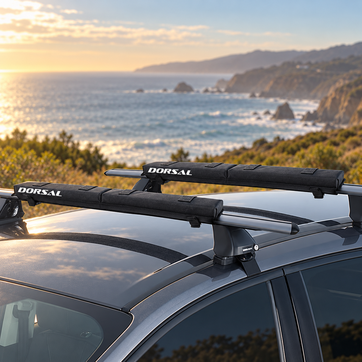 DORSAL folding crossbar pads installed on a vehicle roof rack beside the coast